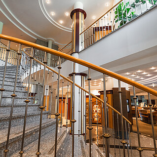 Elegante Wendeltreppe mit Granitstufen und dekorativer Beleuchtung in modernem Atrium