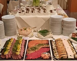 Elegantes Buffet mit Aufschnitt, Räucherfisch und Vorspeisen auf weißen Tischdecken