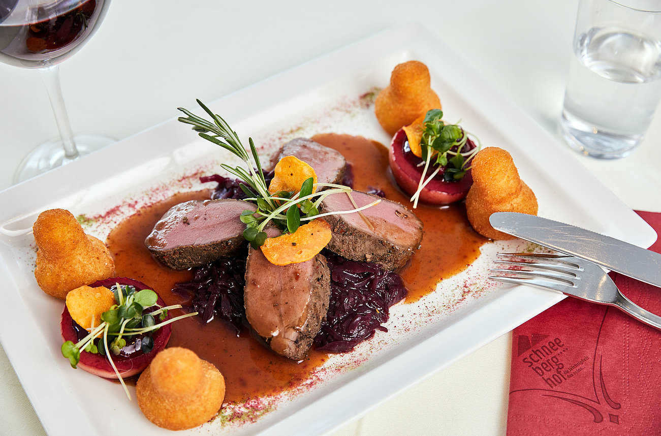 Gourmet-Hirschmedaillons mit Rotkraut, Soße, Herzoginkartoffeln und garnierten Rote-Bete-Scheiben