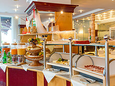 Hotel Frühstücksbuffet mit frischen Früchten, Saftspendern, Käse und Aufschnitt