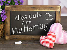 Alles Gute zum Muttertag auf Tafel mit Blumen und Stoffherzen