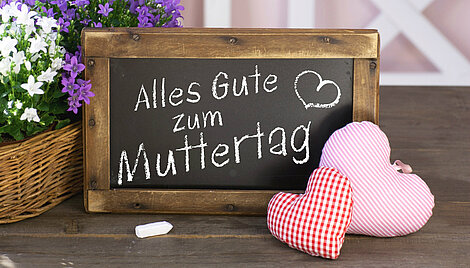 Alles Gute zum Muttertag auf Tafel mit Blumen und Stoffherzen