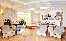 Moderner Spa-Ruhebereich mit Rattanliegen, Holzboden, Pflanzen und Wellness-Dekoration