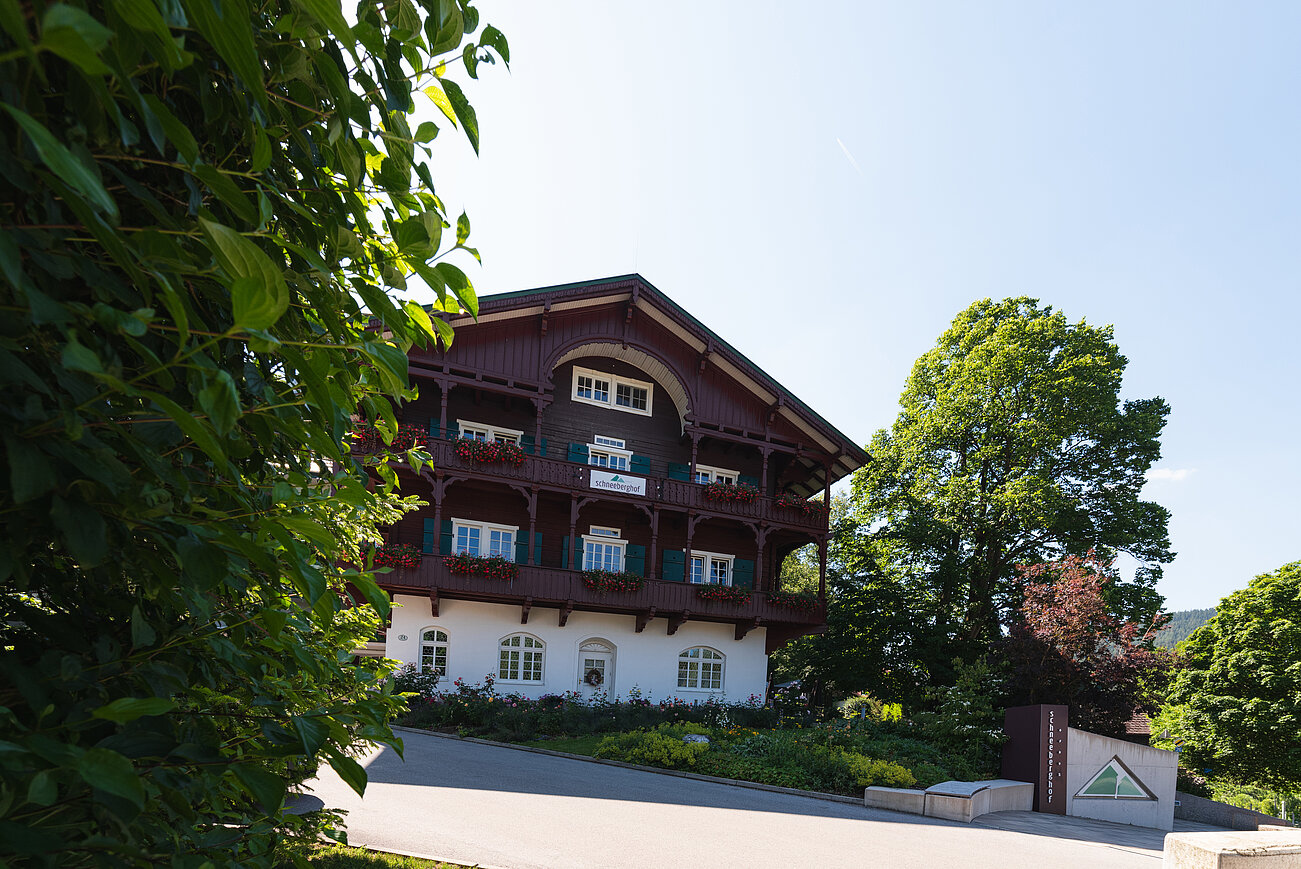 Traditionelles Holzchalet mit blumengeschmückten Balkonen und üppigem Grün