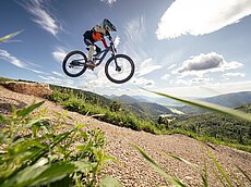 Mountainbiker springt auf Strecke mit malerischer Bergsicht