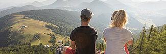 Paar sitzt auf Decke und genießt die Panorama-Aussicht bei einer Sommerwanderung