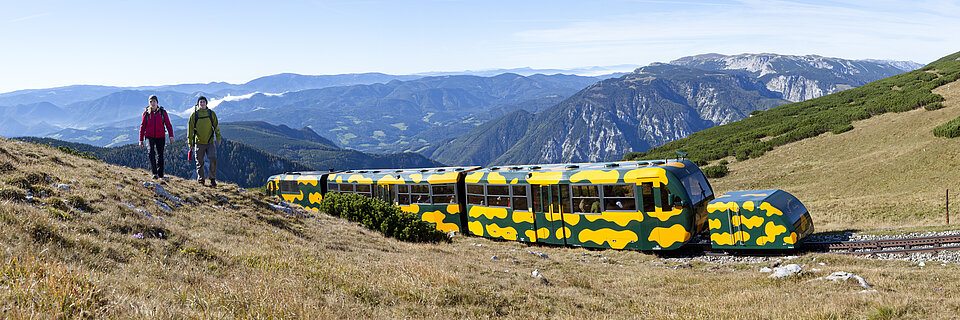 Wanderer begleitet von der Schneebergbahn Salamander – Top Sehenswürdigkeit für Familien und Aktivurlauber