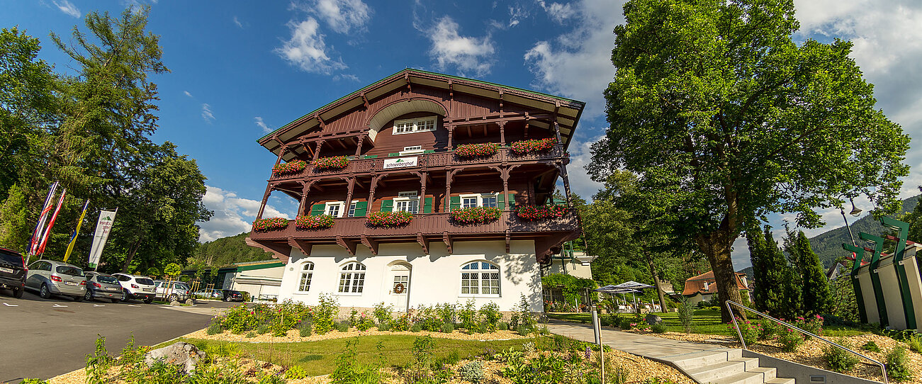 Traditionelles Alpenhotel Schneeberghof mit Blumenkästen und Bergkulisse