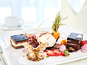 Gourmet-Dessertteller mit Schokoladenkuchen, Eiscreme, Obst und dekorativem Schmetterling aus Schokolade