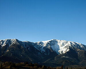 Schneebedecktes Gebirge unter klarem blauen Himmel in winterlicher Landschaft